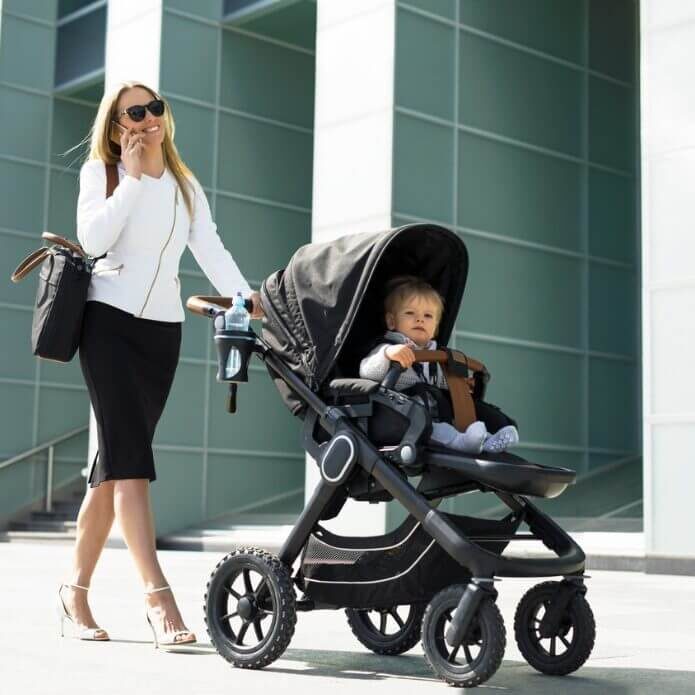 business-woman-with-baby-carriage-walking-and-talking-on-the-phone-picture-id852047318-square